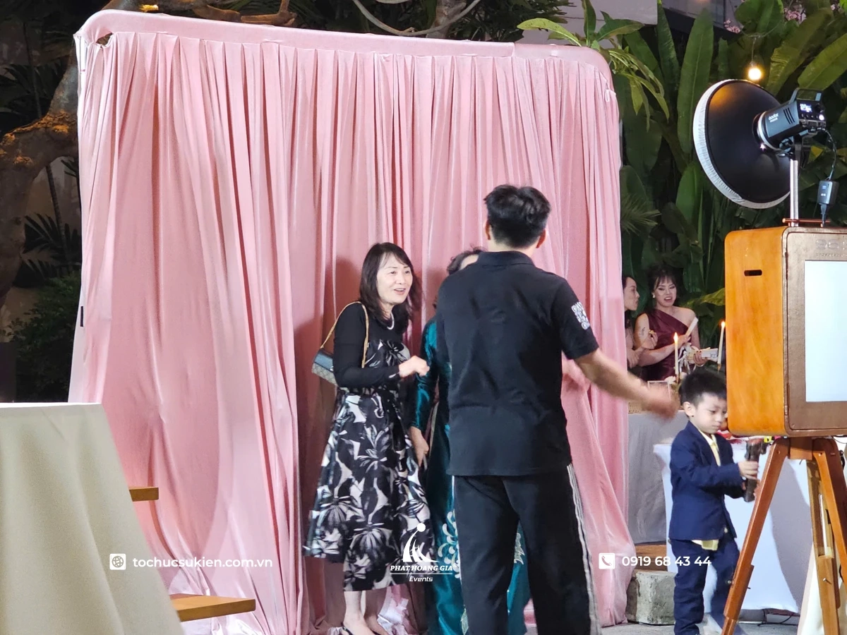 Khách mời hào hứng check-in và chụp ảnh lấy liền tại khu vực photo booth lễ ra mắt Aura Pro Max với sự hướng dẫn của nhân viên.